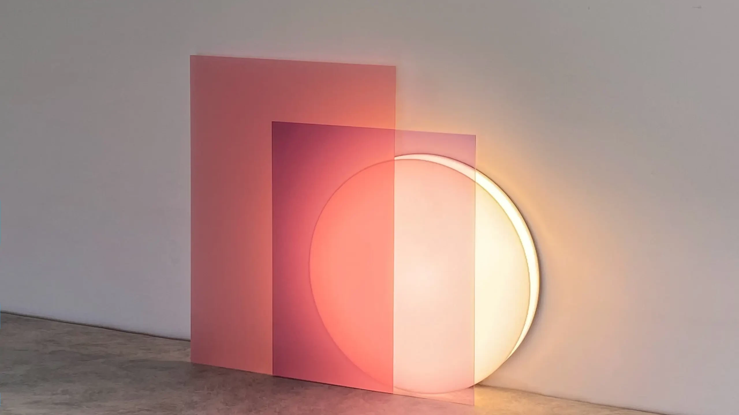 The Lune floor lamp is leaning against a wall