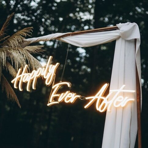 Happy Ever After yellow neon light hanging outside